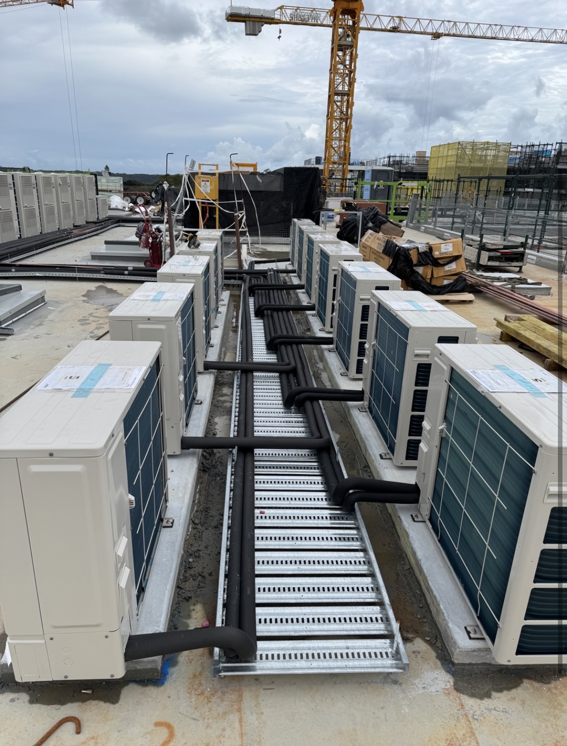 Multiple outdoor air conditioning condenser units with insulated pipework installed on a rooftop