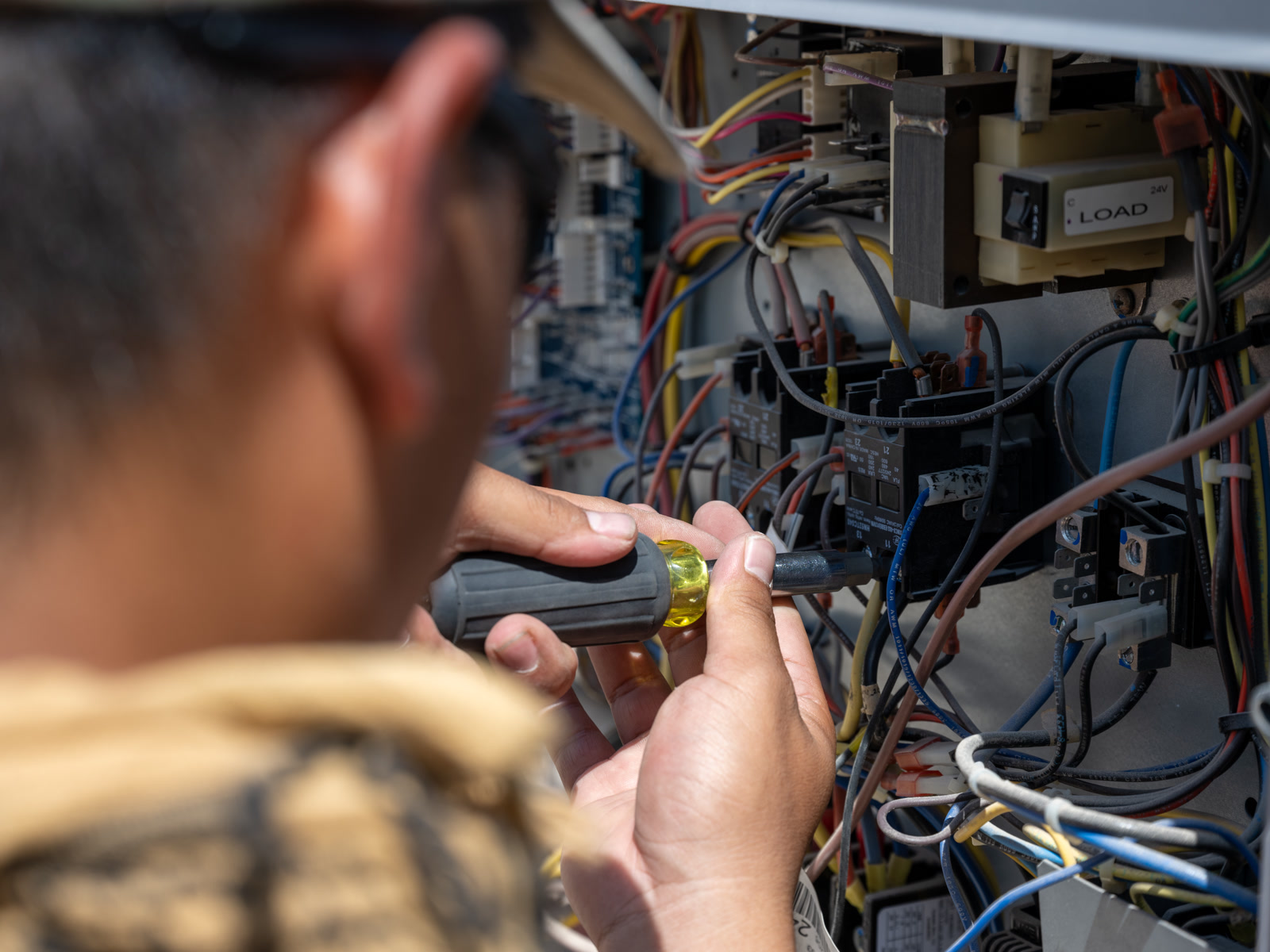 Technician repairing the electrical panel of an air conditioning unit